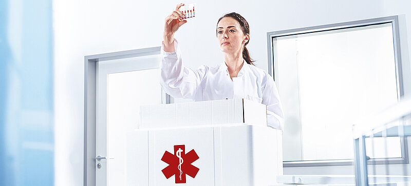 
		  A woman removing a test tube from an insulated box